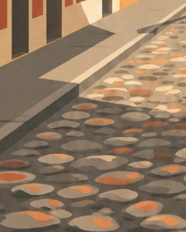 The rounded cobbles with ochre reflections and the shadows along the pavement