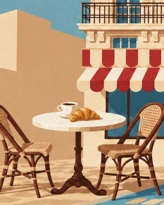 Café et croissant sur la table ronde en marbre, entre 2 chaises cannées, sous l'auvent rayé rouge