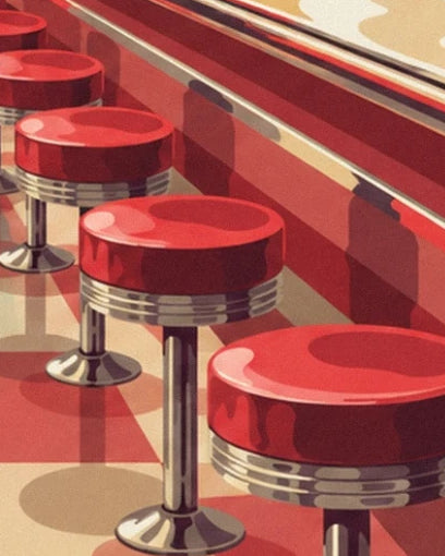 Red stools with chrome legs lined up along the diner counter