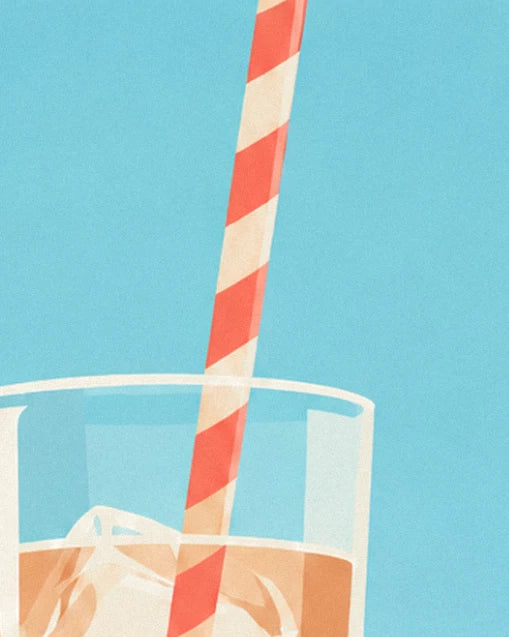 La paille rayée rouge et crème plongée dans le café glacé, sous un ciel bleu