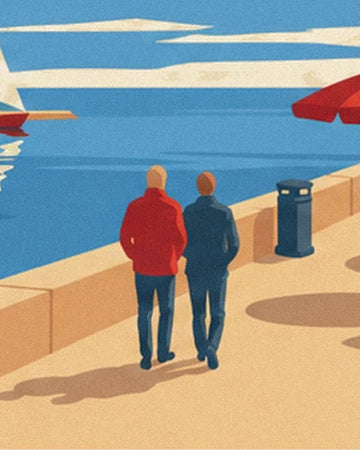 The 2 walkers in red and blue jackets on the sunlit quay beside the water