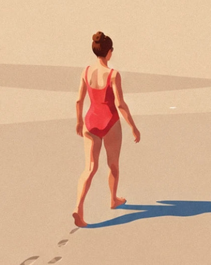 Une femme de dos en maillot rouge, pieds nus sur le sable doré du Sillon