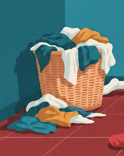 Le panier en osier débordant de linge blanc, bleu et jaune sur le carrelage rouge