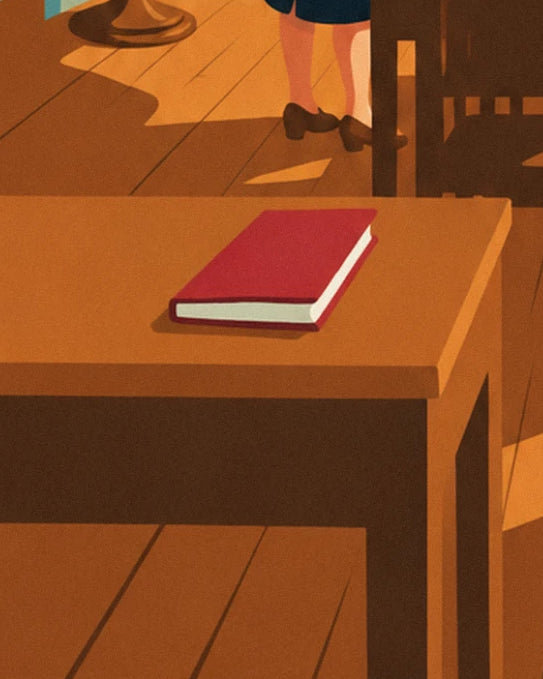 Un libro rojo sobre un pupitre de madera, encima del suelo de madera pulida del aula