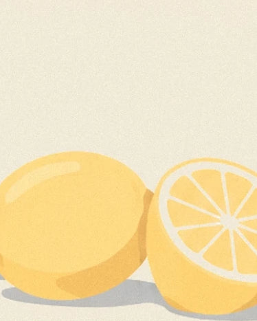 A whole lemon and a lemon half with yellow flesh against a cream background