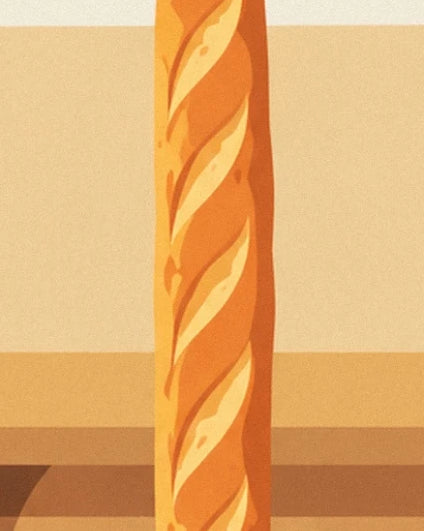 A golden baguette with diagonal cuts in front of the bakery’s cream wall