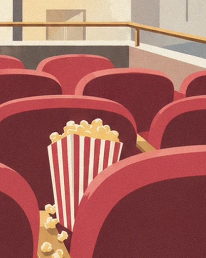 Un cornet de pop-corn rayé rouge et blanc posé entre les fauteuils rouges