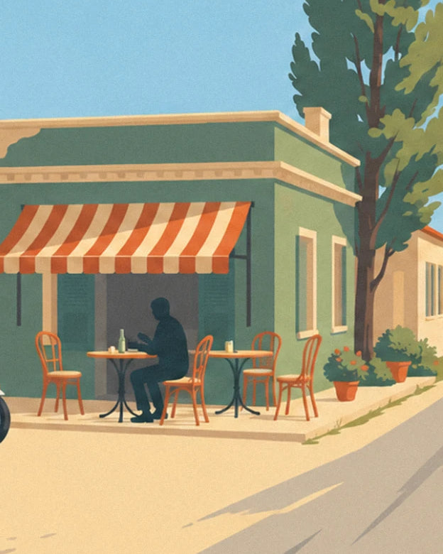 The green café terrace beneath its orange striped awning, with a customer at a table