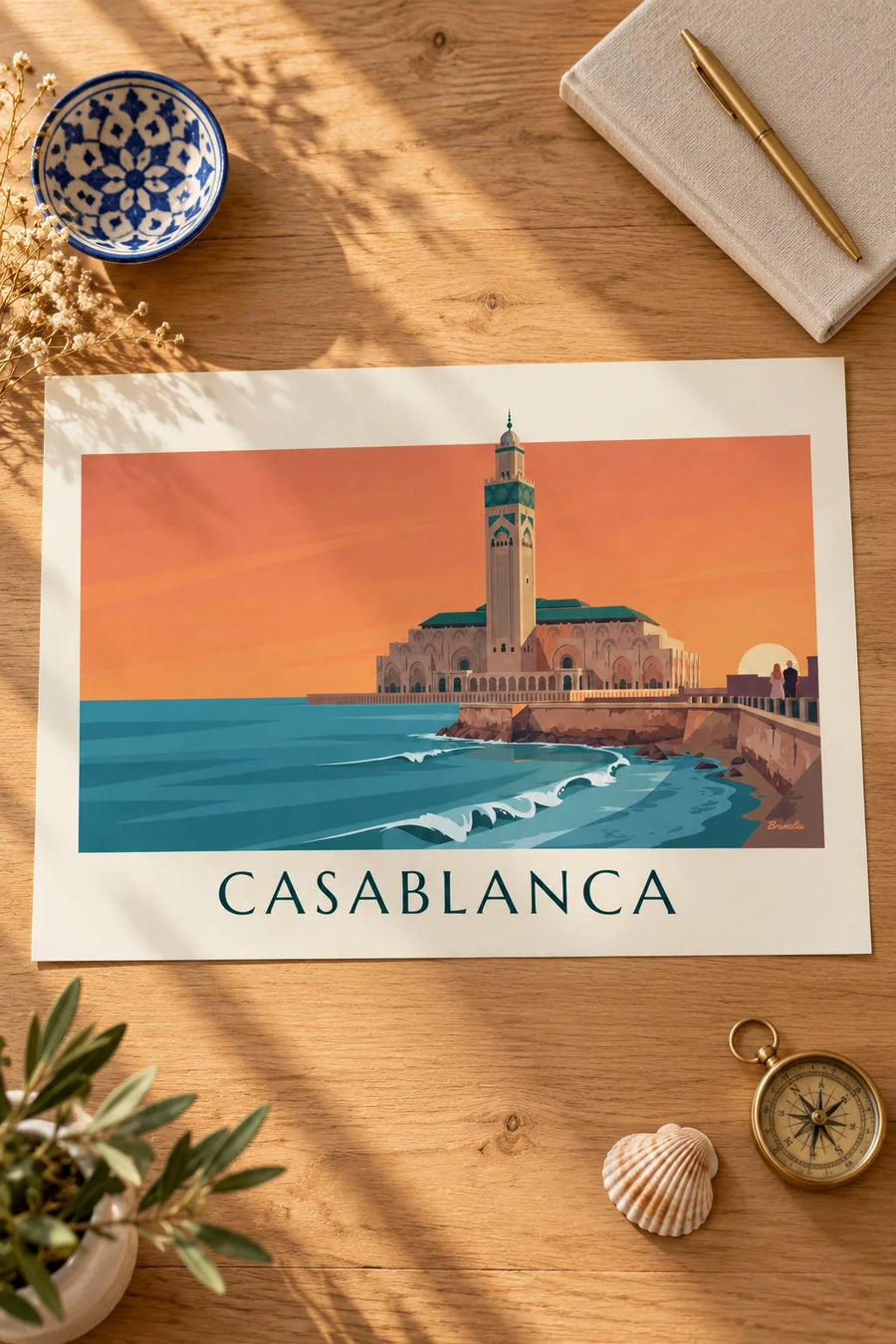 Póster mezquita Hassan II frente al océano al atardecer: colocado sobre una mesa
