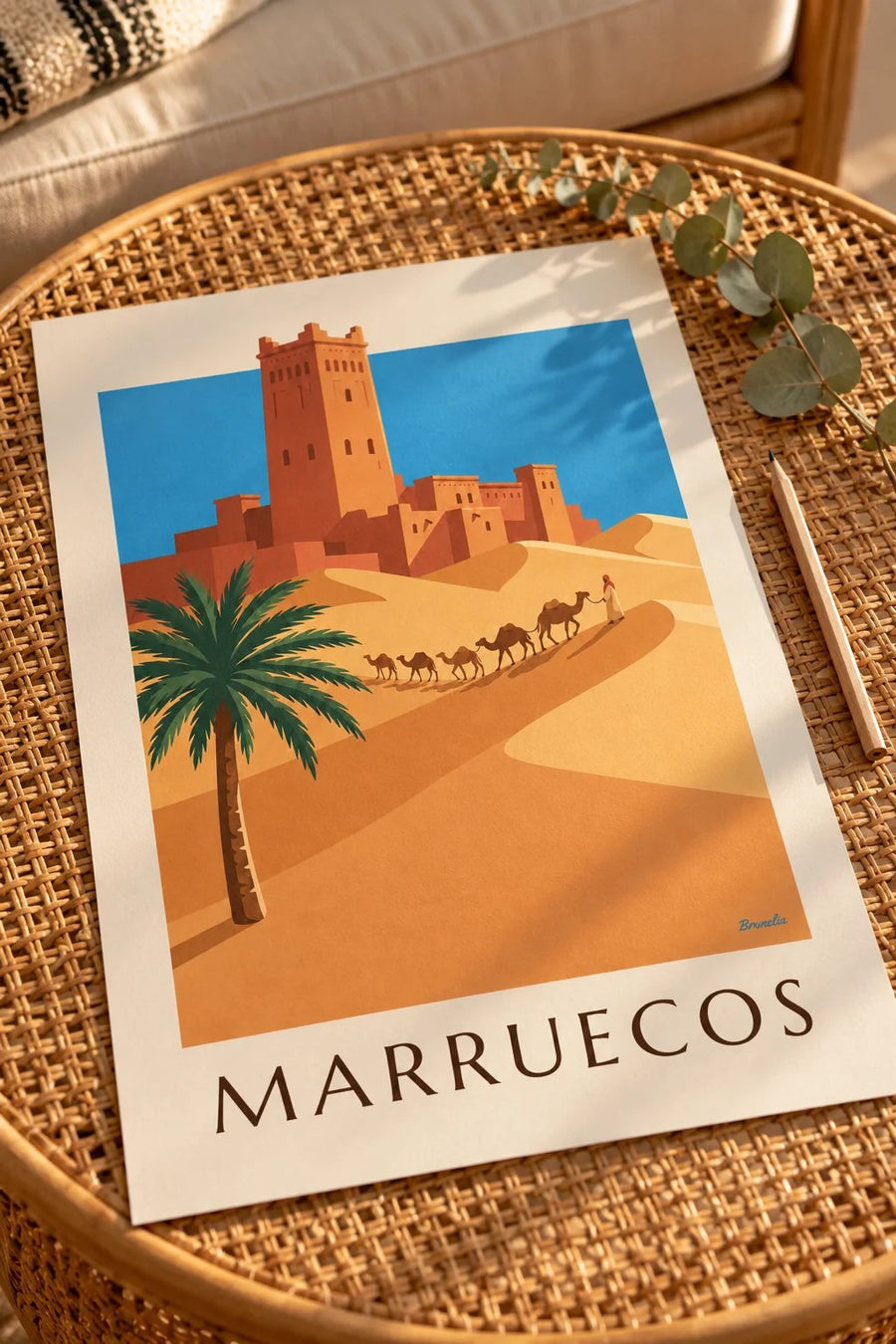 Póster de kasbah y caravana de camellos en el desierto marroquí: colocado sobre una mesa