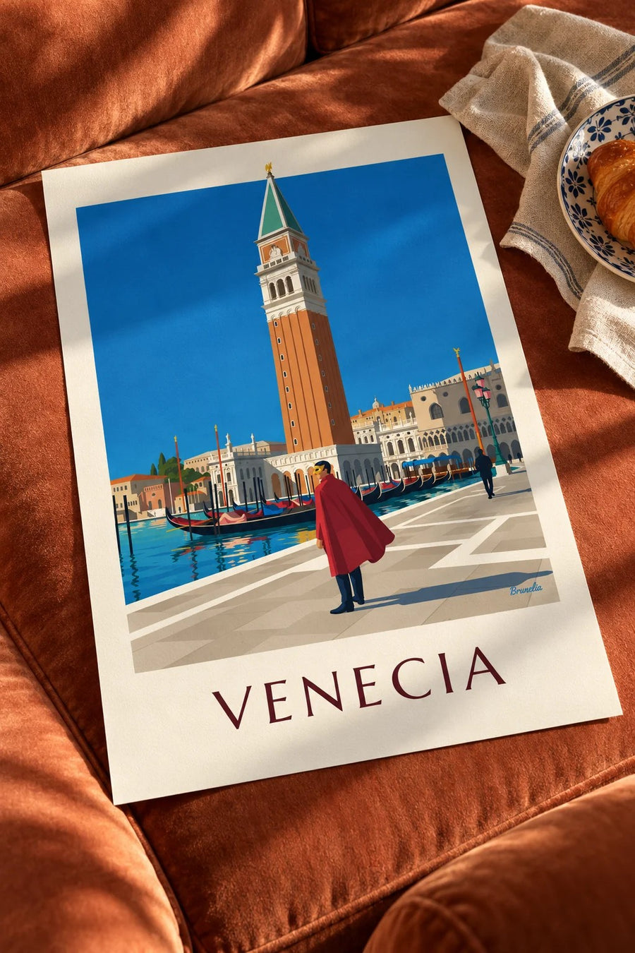 Póster hombre enmascarado con capa roja frente al campanile de San Marcos: sobre una mesa