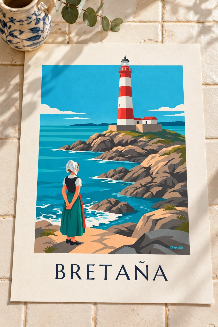 Póster mujer con tocado bretón frente a un faro rojo y blanco: colocado sobre una mesa