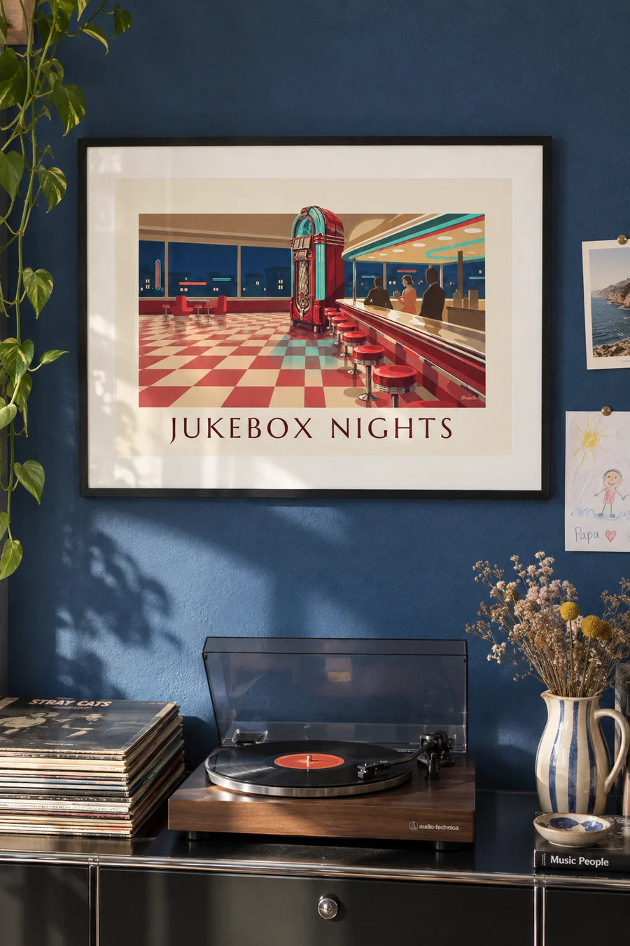 Poster of a glowing jukebox in an American diner: framed on the wall