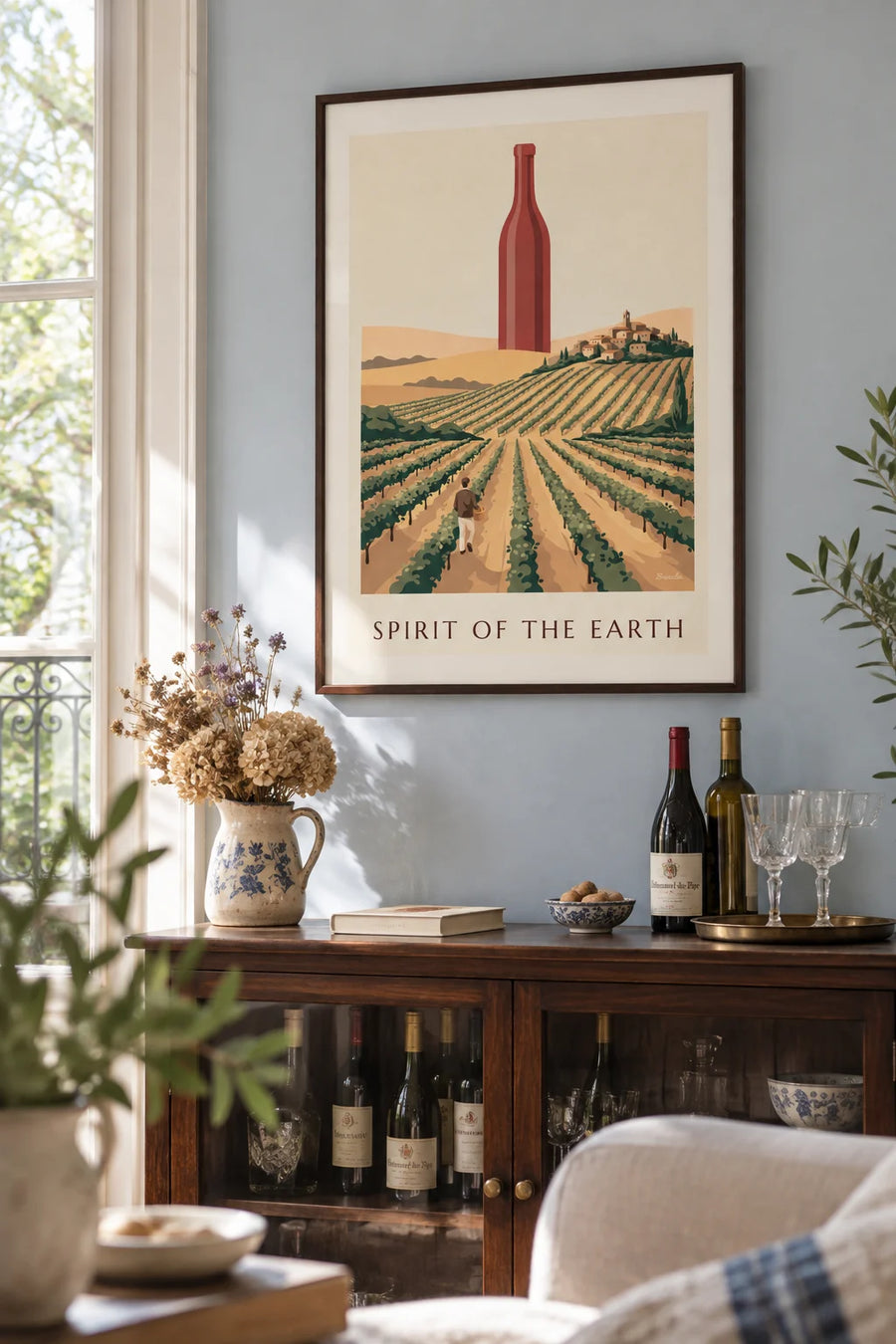 Poster of a bottle of red wine among countryside vineyards: framed on the wall