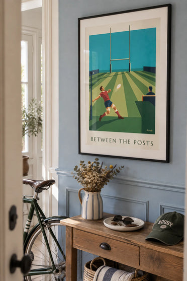 Poster of a rugby kicker and ball heading toward the stadium posts: framed on the wall