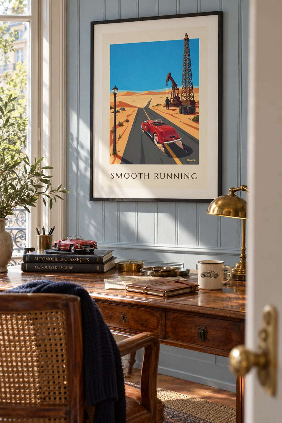 Poster of a roadster on a desert road with an oil derrick: framed on the wall